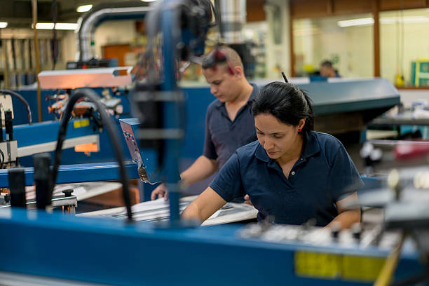 Operarios en máquina de estampado industrial